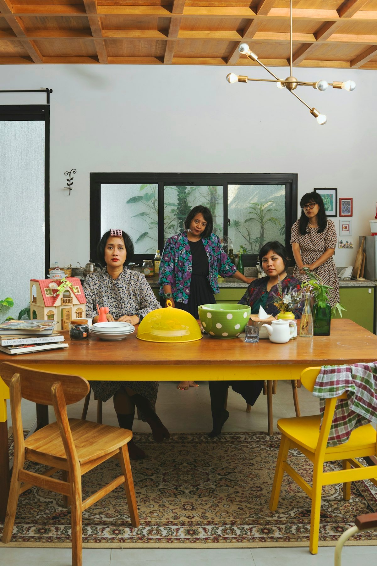 Four women of a family gathered around a dining table with dishes at home