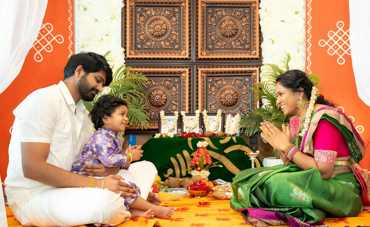 A family sitting together at home in front of a decorated wall