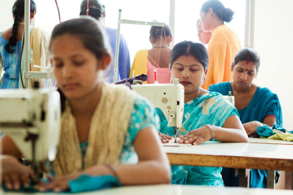 Women learning at sewing machines in a training room