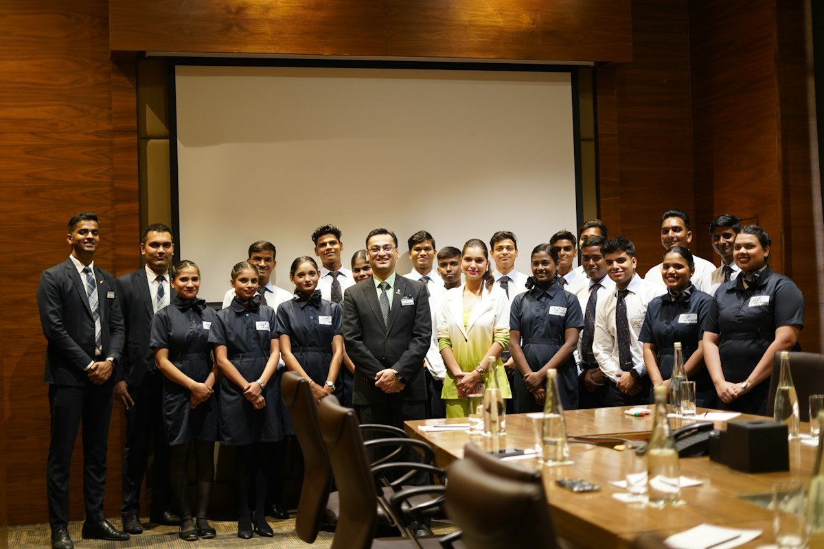 A large staff team in formal clothes posing in a conference room