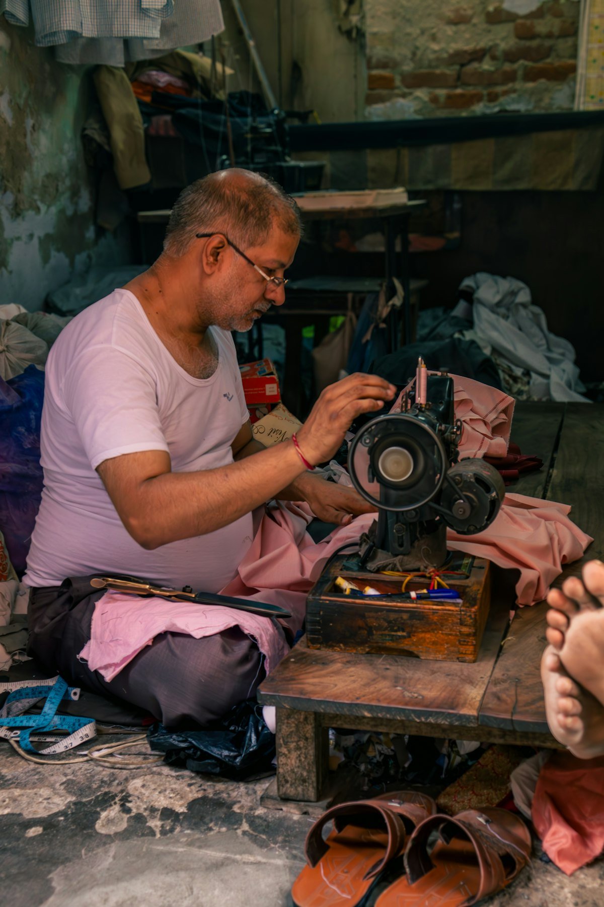 A tailor working at a vintage sewing machine, close-up