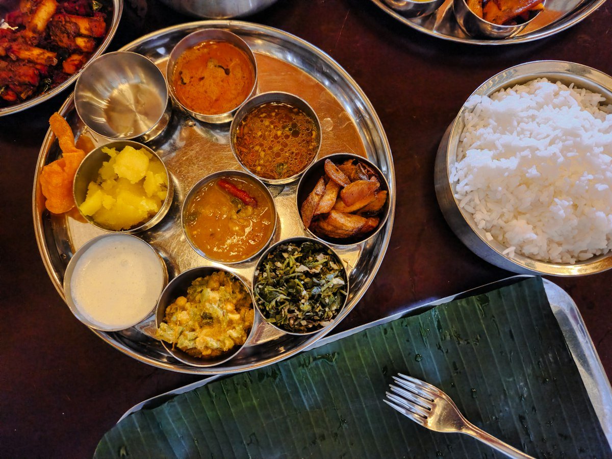 An Indian thali with rice, dal and several side dishes in small bowls