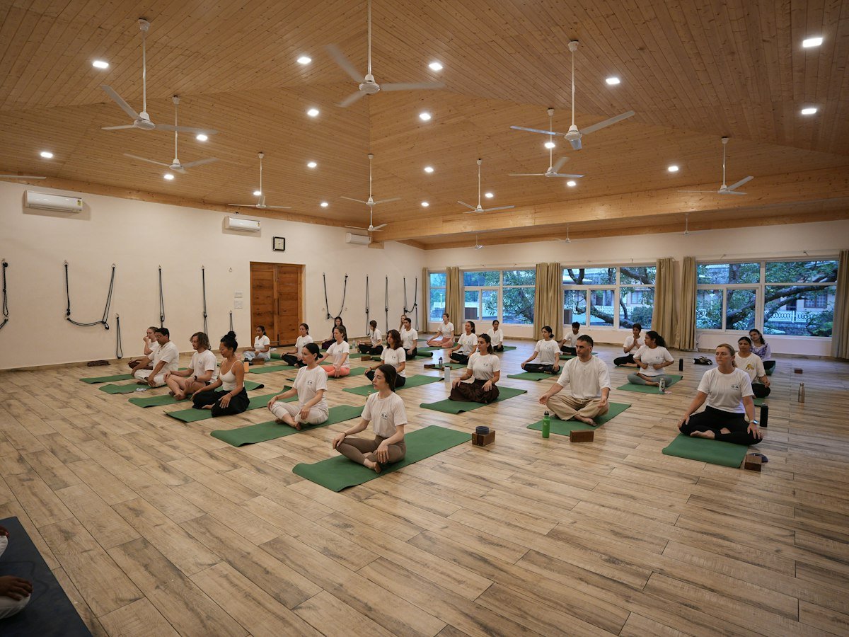 A group of people meditating on mats in a yoga hall